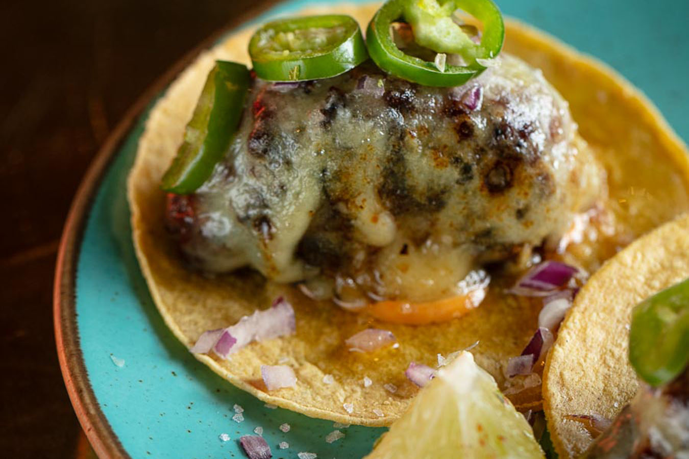 A plate with two tacos garnished with a lime, served at Temper restaurant