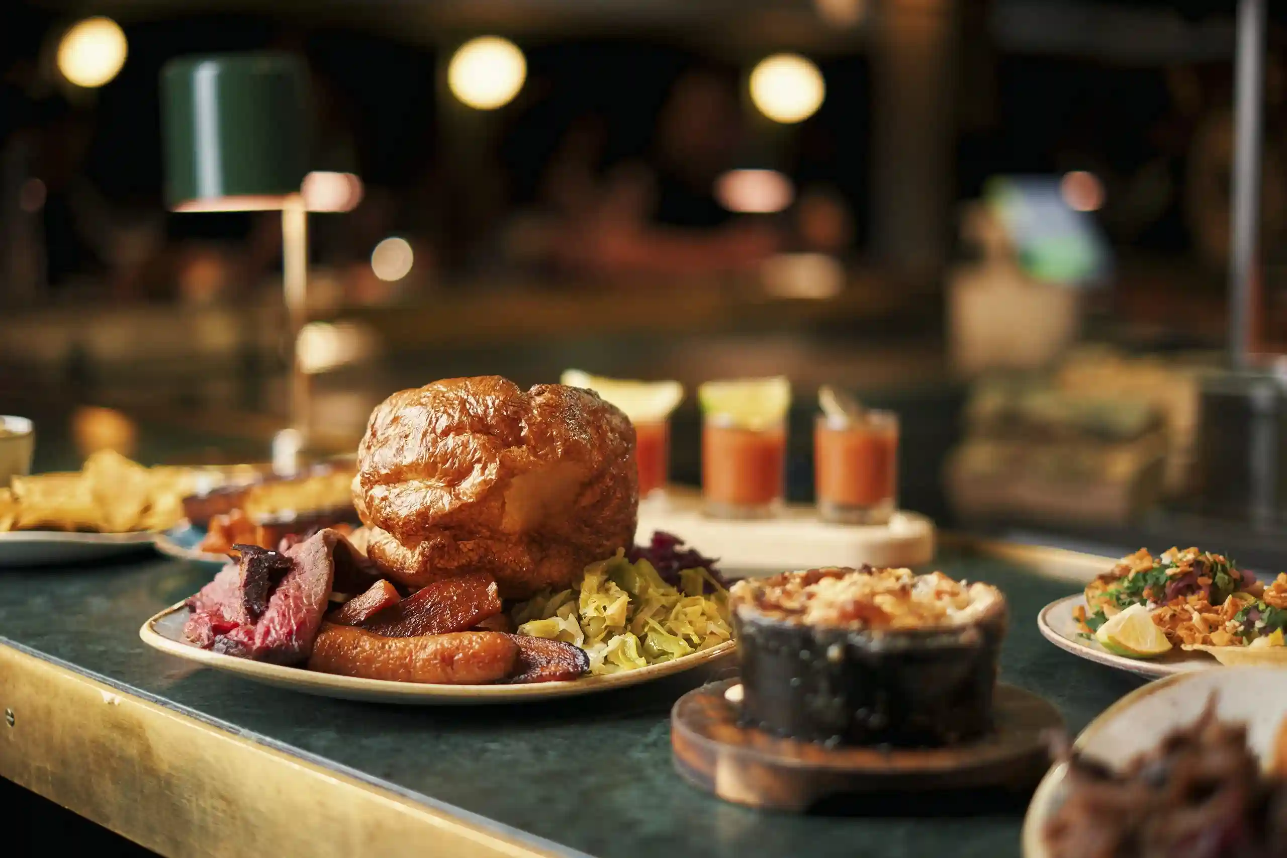 A dining table adorned with multiple plates of food, featuring offerings from Temper Restaurant in Central London