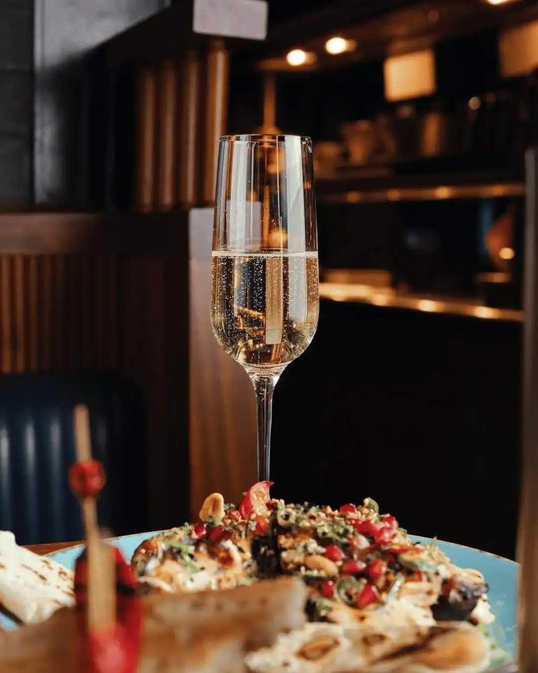 A plate of fire-cooked steak and sides, accompanied by a glass of red wine, from Temper Restaurant in Central London