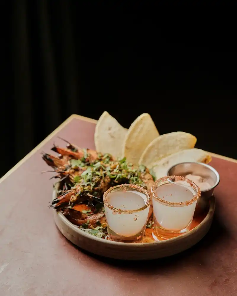 A dish of shrimp and tortillas presented at Temper Restaurant, known for its fire-cooked steaks and handmade tacos